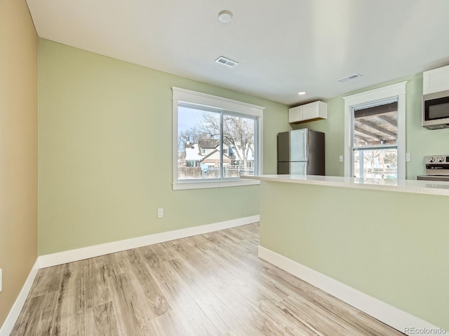 kitchen featuring white cabinets, stainless steel appliances, and light wood-type flooring