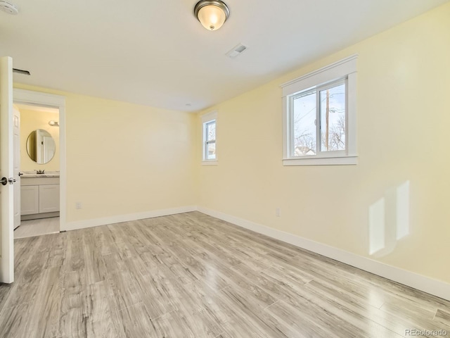 unfurnished room featuring light wood-type flooring and sink