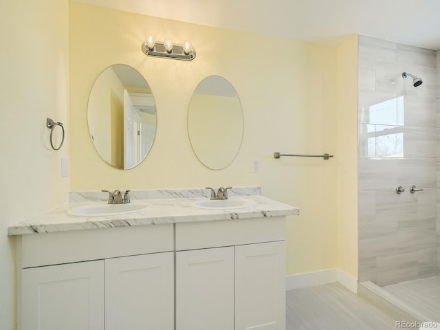 bathroom with vanity and a tile shower