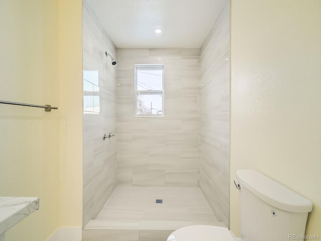 bathroom with toilet and a tile shower