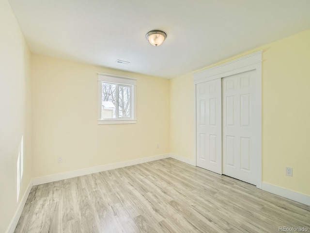 unfurnished bedroom with a closet and light hardwood / wood-style flooring