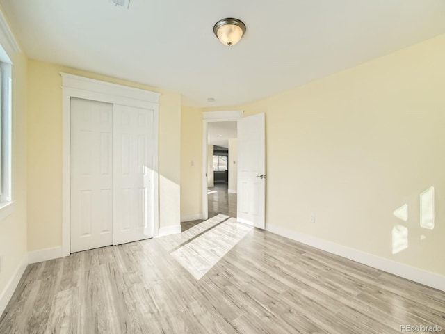 unfurnished bedroom featuring light hardwood / wood-style floors and a closet