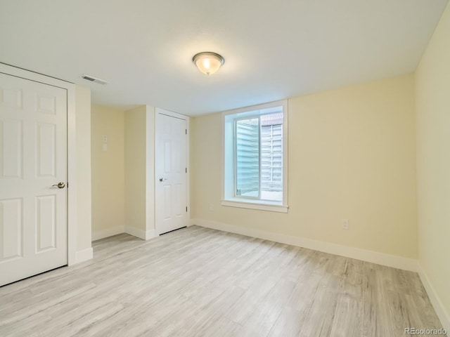 unfurnished bedroom with light wood-type flooring and a closet