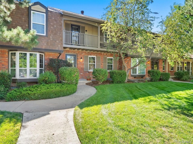 view of front of property with a balcony and a front lawn