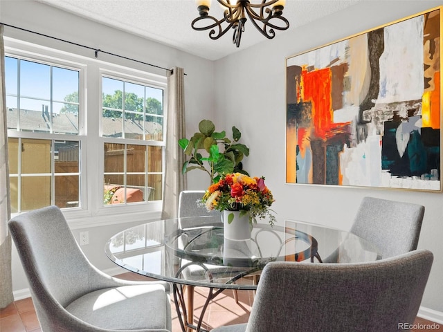 dining area featuring an inviting chandelier, a textured ceiling, and tile patterned floors