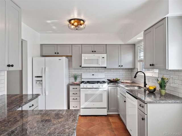 kitchen with decorative backsplash, gray cabinets, tile patterned flooring, sink, and white appliances