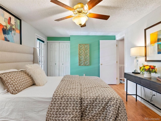 bedroom featuring ceiling fan, a closet, a textured ceiling, and light hardwood / wood-style flooring