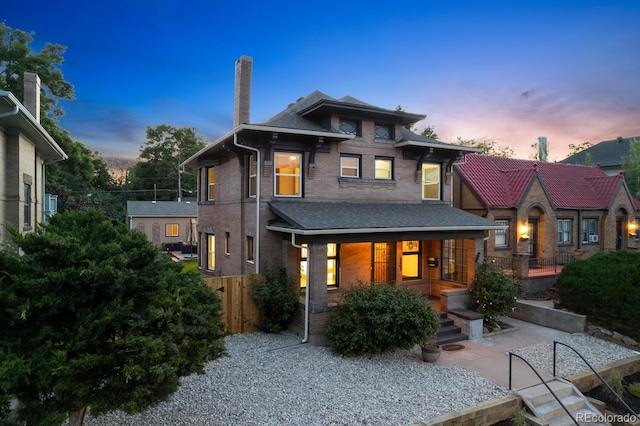 back house at dusk with a patio area