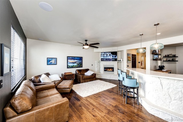 living room with a premium fireplace, ceiling fan, and dark hardwood / wood-style floors