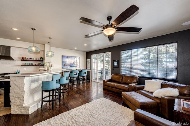 living room featuring ceiling fan and dark hardwood / wood-style flooring