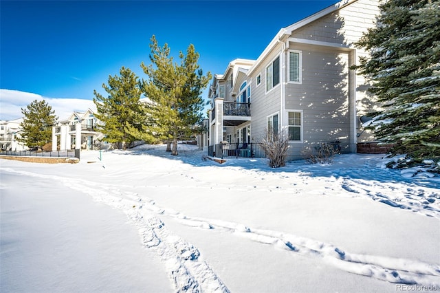 view of snowy exterior with a balcony