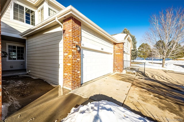 view of side of property with concrete driveway and brick siding