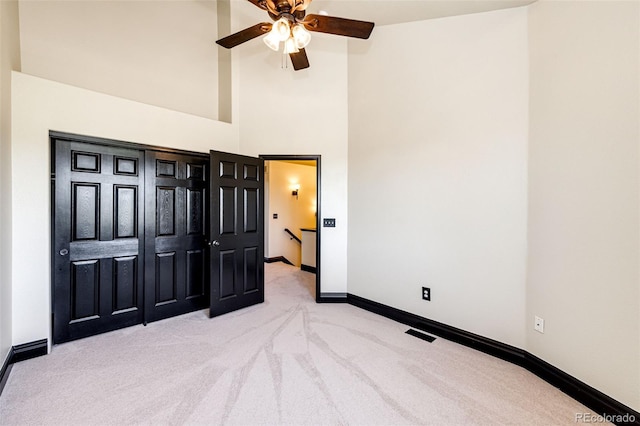 unfurnished bedroom featuring carpet, baseboards, and high vaulted ceiling