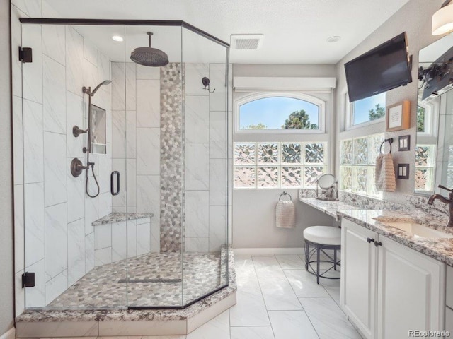 9531 Desert Willow Way, Highlands Ranch, CO 80129 - full bath with marble look tiles, vanity, a stall shower, baseboards, and recessed lighting