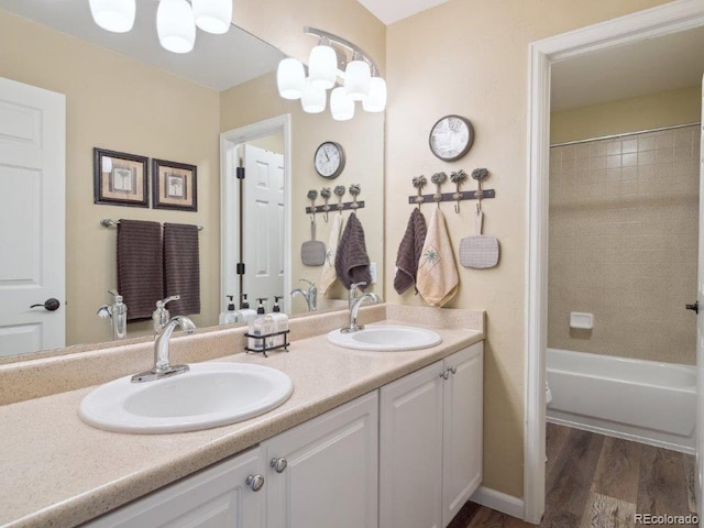 9531 Desert Willow Way, Highlands Ranch, CO 80129 - bathroom featuring double vanity, wood finished floors, tub / shower combination, and a chandelier