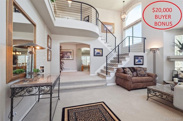 9531 Desert Willow Way, Highlands Ranch, CO 80129 - entryway featuring a towering ceiling, carpet flooring, arched walkways, stairway, and healthy amount of natural light