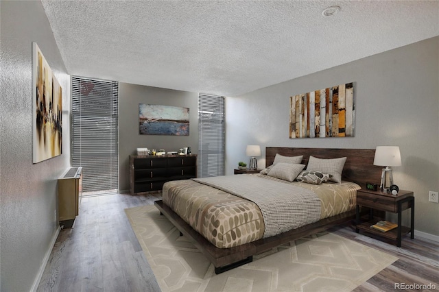 bedroom with light hardwood / wood-style flooring and a textured ceiling