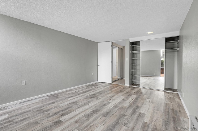 unfurnished bedroom featuring light hardwood / wood-style floors and a textured ceiling