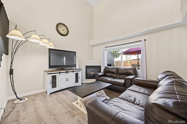11100 Callaway Ct, Parker, CO 80138 - living room featuring high vaulted ceiling, light wood finished floors, and a glass covered fireplace