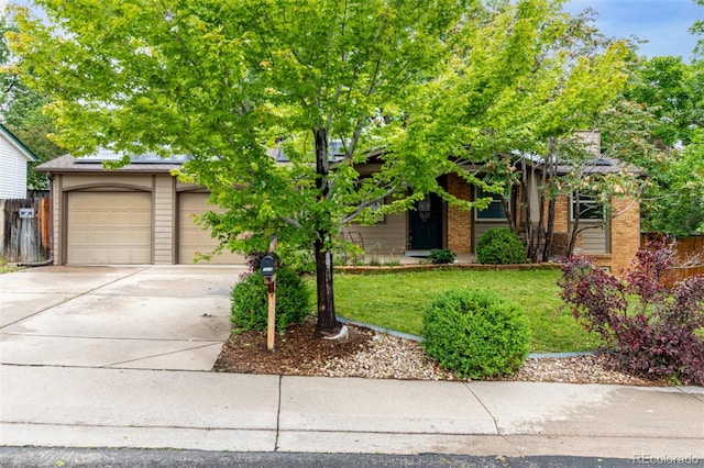 7579 Jay Ct, Arvada, CO 80003 - view of property hidden behind natural elements featuring driveway, brick siding, solar panels, and an attached garage