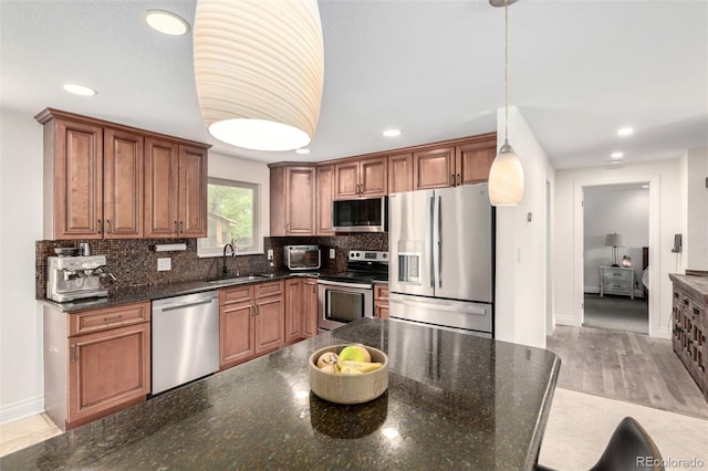 7579 Jay Ct, Arvada, CO 80003 - kitchen featuring stainless steel appliances, a sink, decorative backsplash, recessed lighting, and brown cabinetry