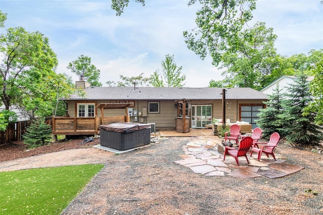 7579 Jay Ct, Arvada, CO 80003 - rear view of house with a hot tub, a patio, a wooden deck, and a chimney