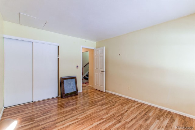 unfurnished bedroom with a closet and light wood-type flooring