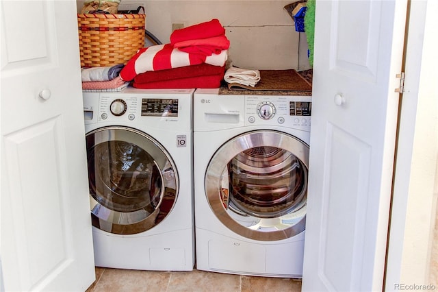 laundry room featuring light tile patterned flooring and washing machine and dryer