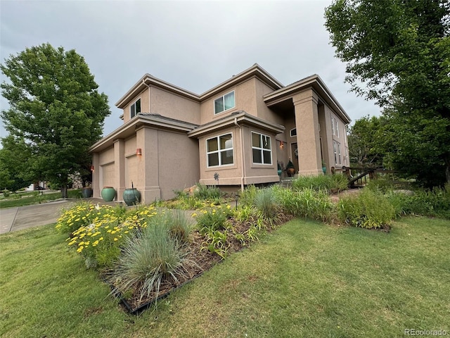 view of side of property featuring concrete driveway, a yard, an attached garage, and stucco siding