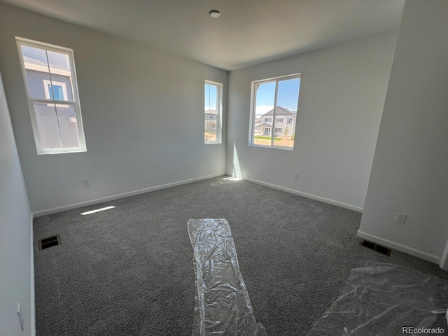 6658 N Nepal Ct, Aurora, CO 80019 - spare room featuring dark colored carpet and baseboards