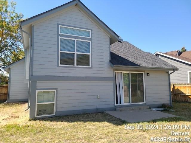 rear view of property with a lawn and a patio