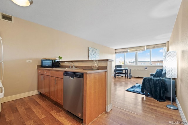 kitchen with dishwasher, sink, light wood-type flooring, and kitchen peninsula