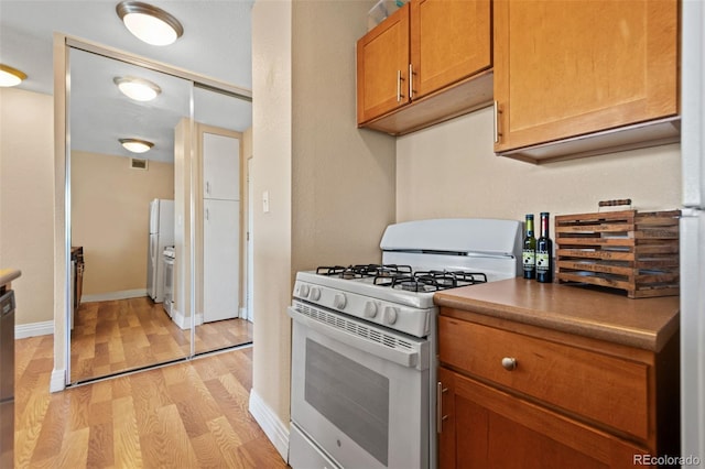 kitchen featuring light hardwood / wood-style flooring and white appliances