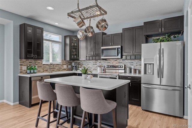 13322 Meadow Park Ln, Broomfield, CO 80020 - kitchen with stainless steel appliances, a kitchen bar, light countertops, glass insert cabinets, and decorative backsplash