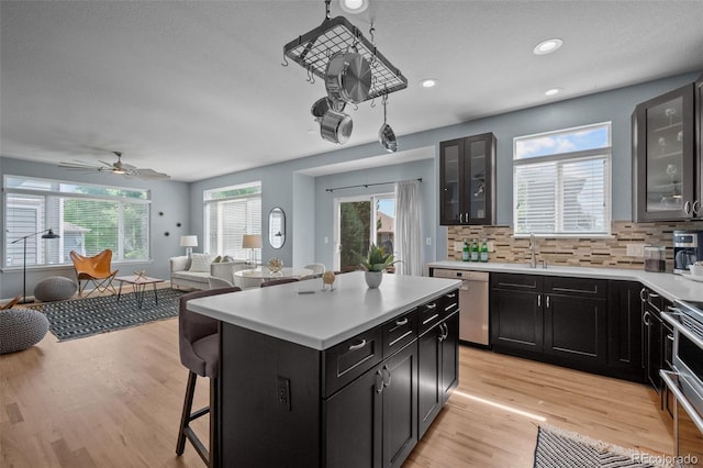 13322 Meadow Park Ln, Broomfield, CO 80020 - kitchen with stainless steel appliances, open floor plan, dark cabinets, a breakfast bar area, and recessed lighting