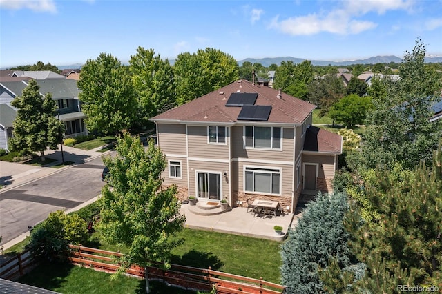 13322 Meadow Park Ln, Broomfield, CO 80020 - back of property featuring roof mounted solar panels, a patio, stone siding, a mountain view, and entry steps