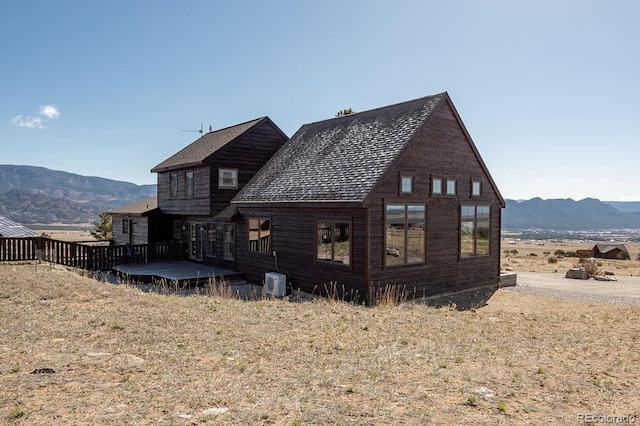 view of property exterior featuring a mountain view and cooling unit