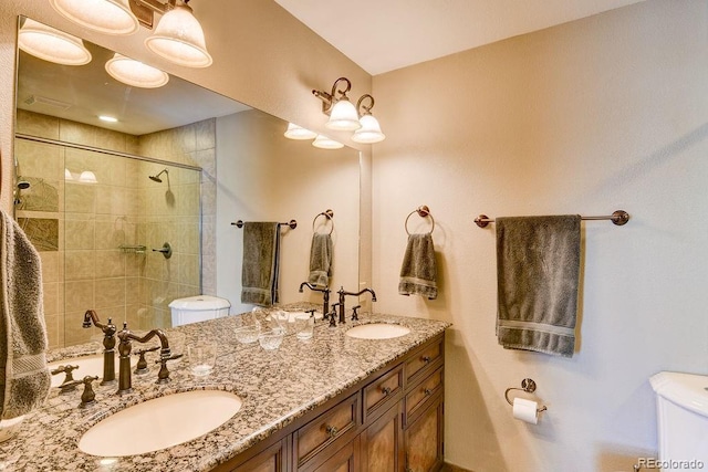 full bath with a sink, a tile shower, and toilet