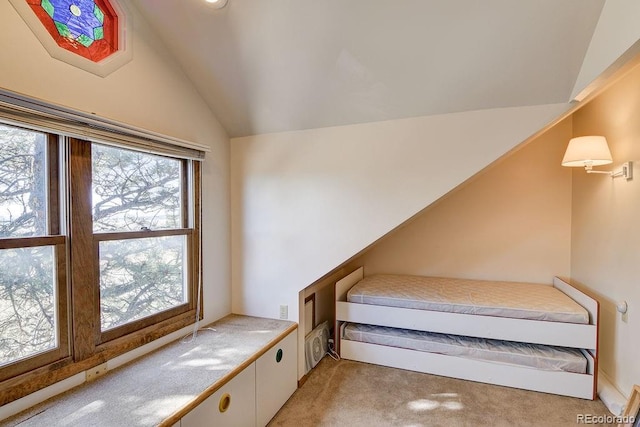 unfurnished bedroom with vaulted ceiling and light carpet