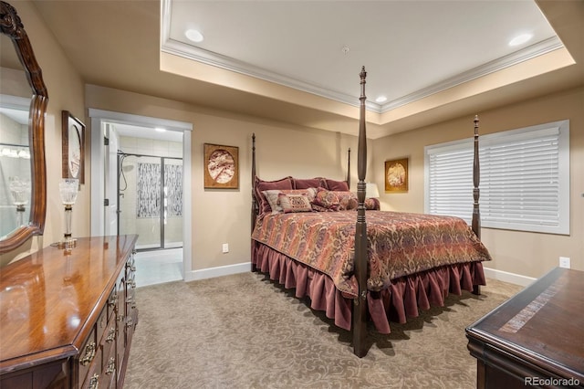 carpeted bedroom with crown molding, ensuite bath, and a raised ceiling