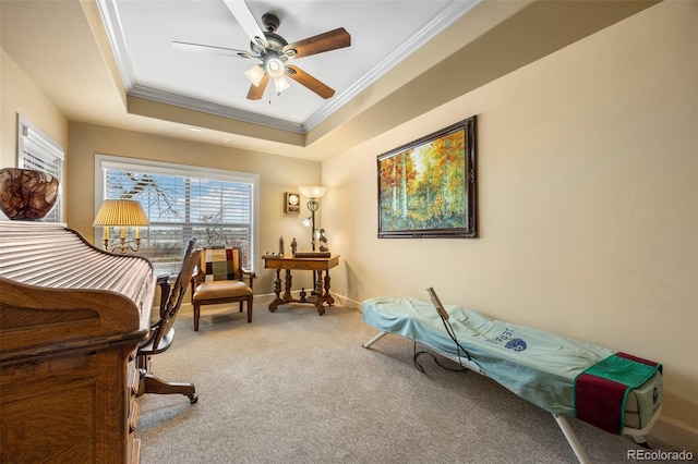 sitting room with a tray ceiling, ornamental molding, carpet, and ceiling fan