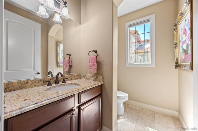 bathroom with toilet, baseboards, and vanity