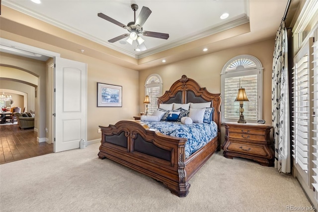 carpeted bedroom featuring crown molding, recessed lighting, arched walkways, baseboards, and a raised ceiling