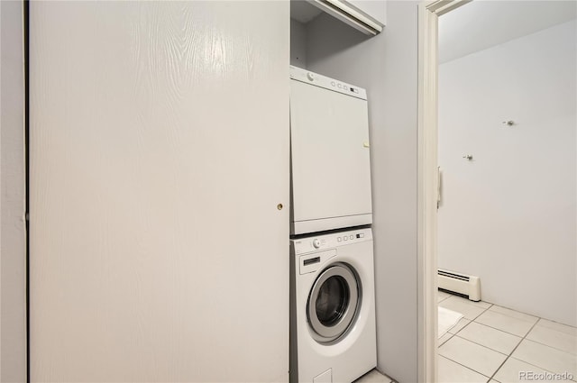 laundry area featuring a baseboard radiator, stacked washing maching and dryer, and light tile patterned floors