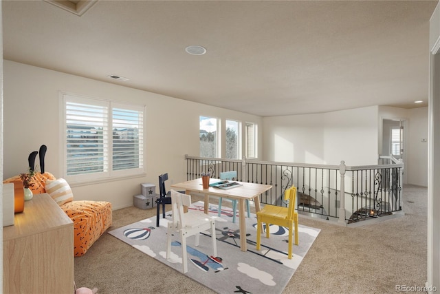 dining space with light colored carpet and a healthy amount of sunlight