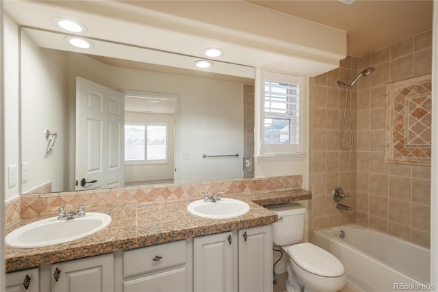 full bathroom with tasteful backsplash, a wealth of natural light, and vanity