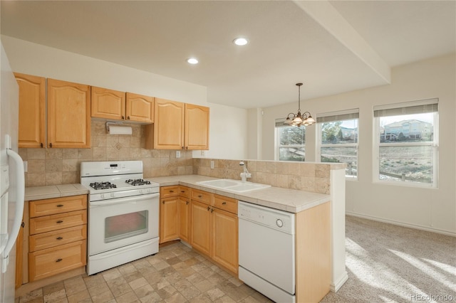 kitchen with tile countertops, white appliances, sink, decorative light fixtures, and a notable chandelier