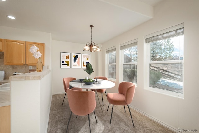 carpeted dining area featuring a chandelier