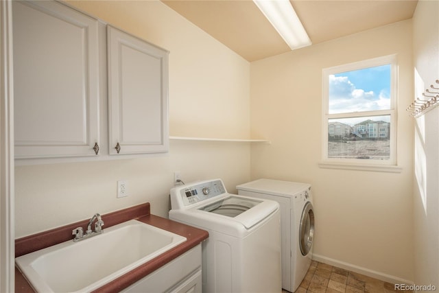 laundry area with cabinets, separate washer and dryer, and sink