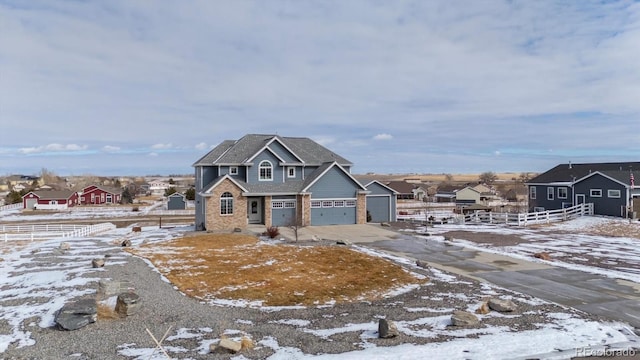 view of front of property with driveway, brick siding, an attached garage, and a residential view